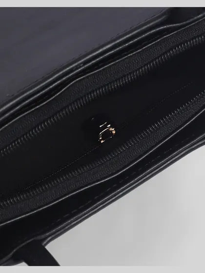A macro shot of the inside of a black purse, focusing on the zipper and quality of the lining.