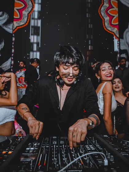 A photo of me smiling while mixing at a show. It shows the genuine joy and passion I have for my craft and for entertaining the crowd.