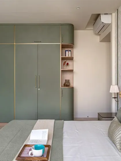 For this master bedroom in Thane, we aimed for simple sophistication. I built the custom wardrobe with curved edges and subtle gold accents to create a soft, luxurious feel. The entire room is designed to be a calm and warm space.