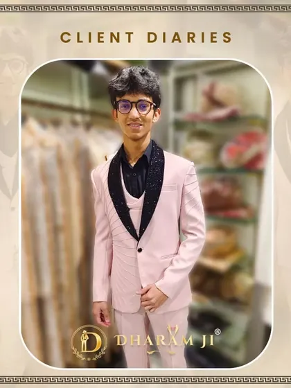 A young client looking very smart in a light pink three-piece suit with a black sparkling lapel. It's a modern and stylish choice for a family function.