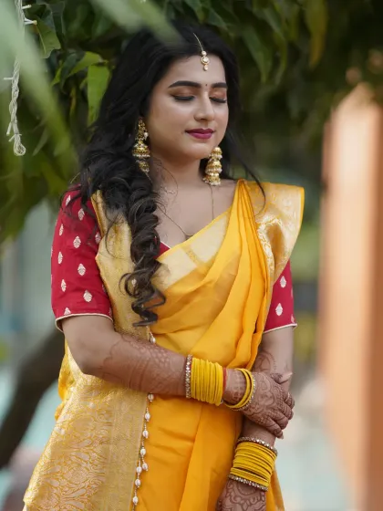 A close-up of the Haldi look, featuring a side braid and soft, rosy makeup.