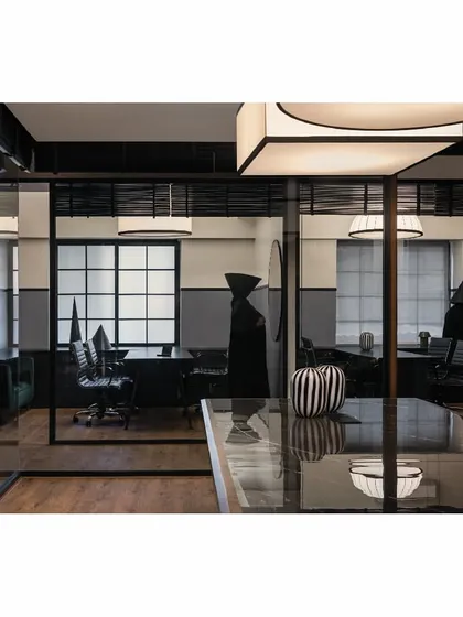 This is from our 'Shadows' project, a modern legal office. We designed the layout to maximize natural light, pushing workspaces toward the windows. The use of glass partitions and a monochrome palette creates a space that feels formal and modern, moving away from traditional law office design to reflect a dynamic, contemporary practice.