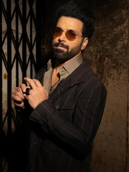 A closer view of Rithvik Dhanjani's ensemble, showing the contrast between the structured, striped wool jacket and the fluid satin kurta underneath. It’s a study in textures and layers.