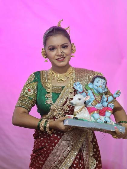 The vibrant colours of the festival come alive in this shot, with a pink background complementing the red and green outfit.