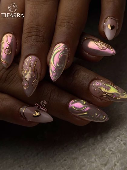 Grace on the surface, fire underneath. This full set of stiletto extensions combines a soft pink base with iridescent chrome and hand-drawn golden flame outlines for a bold look.