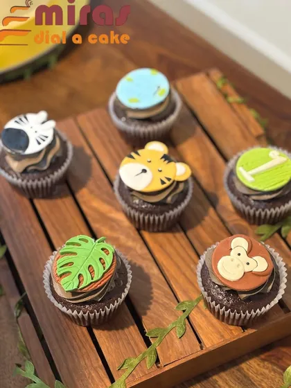 For a child's party, I created these jungle-themed cupcakes. Each chocolate cupcake has a custom-made fondant topper, including a tiger, monkey, zebra, and monstera leaf, showcasing my detailed character work.