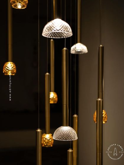This cluster pendant features a mix of gold-toned rods with textured glass shades, some resembling pineapples and others simple domes. The combination creates a visually interesting and warm installation for any corner that needs a lift.