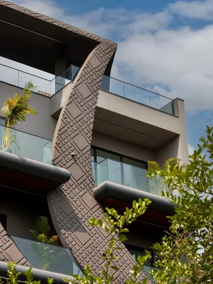 This detail shot of the wave-form facade highlights the way the sculptural concrete elements interact with the building's balconies, creating pockets for greenery.