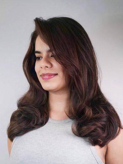 A side profile of the soft brunette waves, showing how the color catches the light to create a gentle, flowing effect.