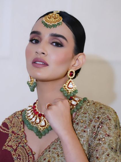 A bold and regal party look with a deep lip color and dramatic eyes, paired with traditional jewelry.