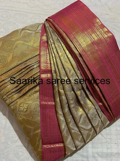 A gold brocade saree with a pink border, perfect for weddings.