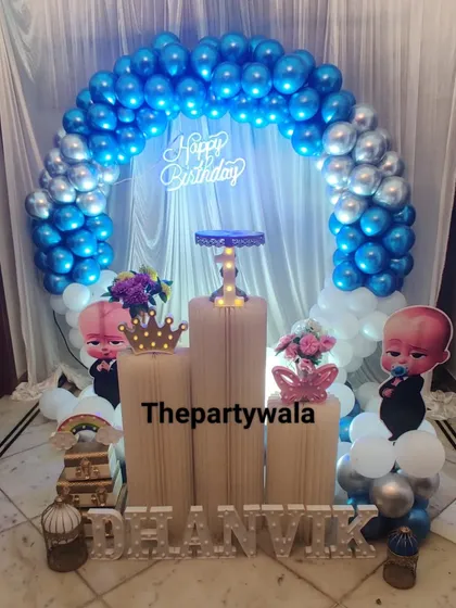 A simple yet effective Boss Baby theme with a blue and silver balloon arch. The character cutouts and light-up crown add a fun, royal touch.