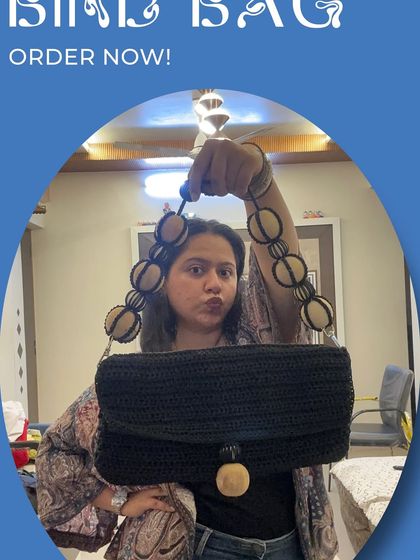 A closer look at one of my custom sling bags. This black bag features a unique beaded handle and a wooden clasp, making it a chic and stylish accessory for a day out.