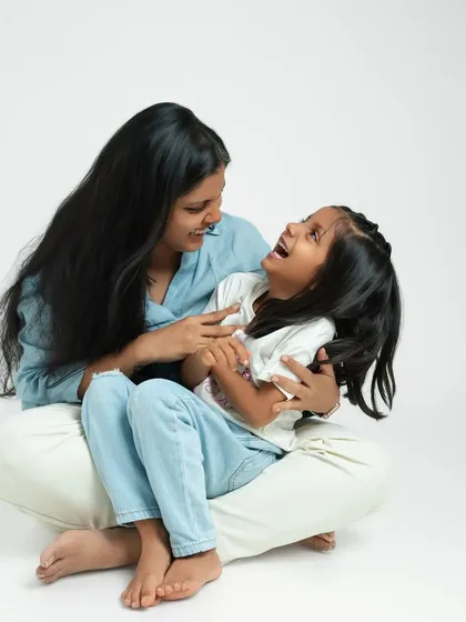 A mother tickles her daughter, eliciting a burst of genuine laughter. My goal is to create a fun and relaxed atmosphere where these natural moments can unfold.