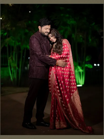 A tender moment between the couple during their evening reception, embracing under the soft glow of outdoor lights.