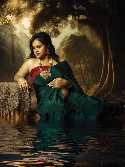 A graceful and artistic portrait of a mom-to-be in a green saree, with a fantasy water reflection edit. This is a unique way to style your maternity shoot.
