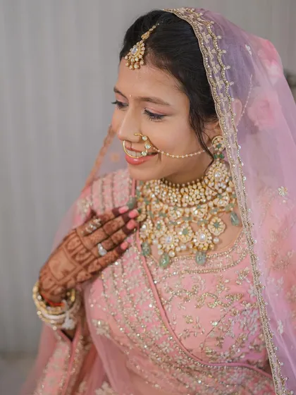 A beautiful close-up showing the soft details of her makeup and the intricate jewelry. A perfect example of understated bridal elegance.