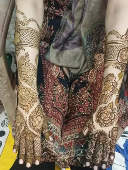 A classic full-hand and arm mehendi design, featuring beautiful floral patterns and detailed jaali (net) work on the wrists.