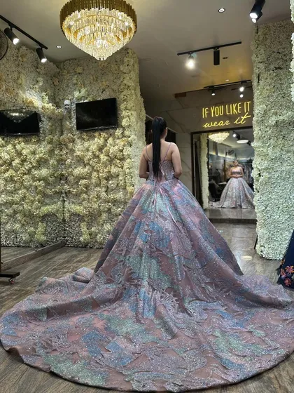 The back view of our multi-colored pastel ball gown, showing off its impressive trail. The corset lacing ensures a perfect fit, while the shimmering, patterned fabric creates a unique and magical look.