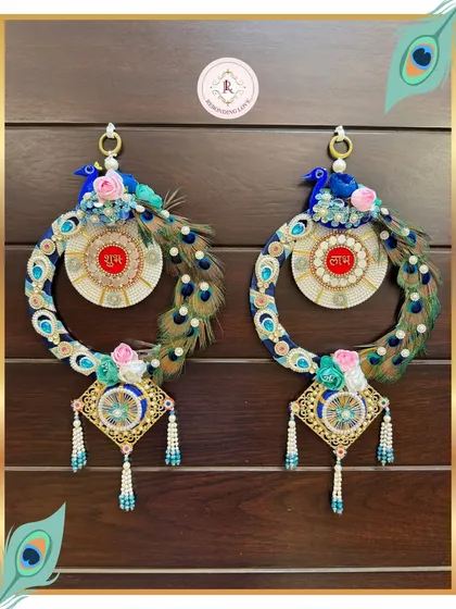 Our peacock Shubh Laabh hangings are a masterpiece of luxury and tradition. We use real peacock feathers, lustrous pearls, and detailed embroidery to create these auspicious pieces that bring grace and good fortune to your home.