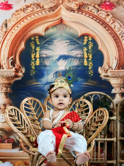 A regal portrait of baby Krishna on his wicker throne, looking poised and charming.