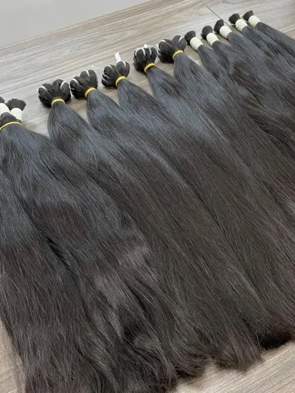 As a direct manufacturer, I source and process premium raw Indian Remy temple hair. This image shows bundles of our high-quality, unprocessed hair ready to be made into extensions, wigs, and toppers for my wholesale clients.