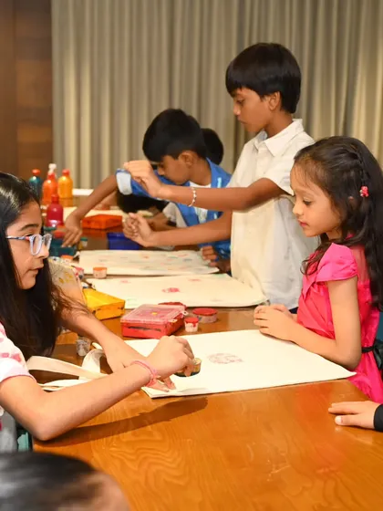 A group of children are completely absorbed in a tote bag painting activity, using stamps and brushes to create their designs. Our workshops for kids are designed to be engaging, fun, and a great way for them to express their creativity.
