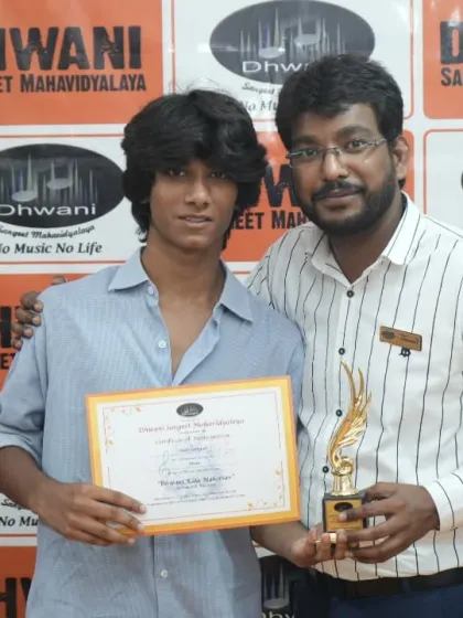 A teacher congratulates his student on his well-deserved award.