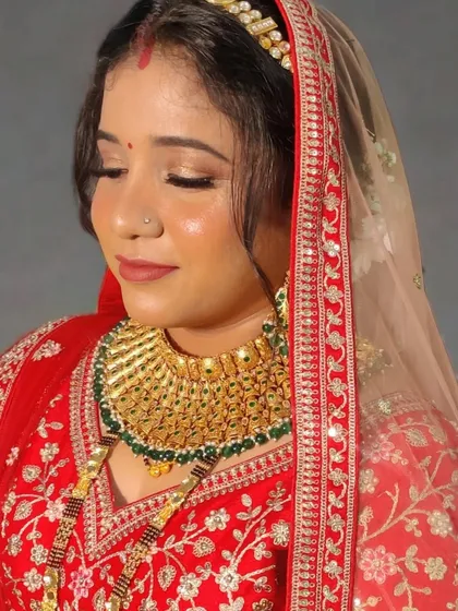 My reception bride Urmila in a classic red lehenga. The makeup features glowing skin and soft gold eyes.