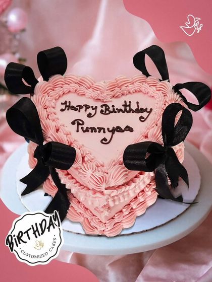 A beautiful heart-shaped cake with pink ruffles and elegant black bows. A perfect blend of sweet and chic for a special birthday.