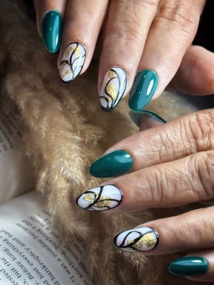 This edgy and chic set features deep green nails paired with abstract art on a white base. The accent nails are detailed with black lines and luxurious gold foil, creating a bold and artistic statement.