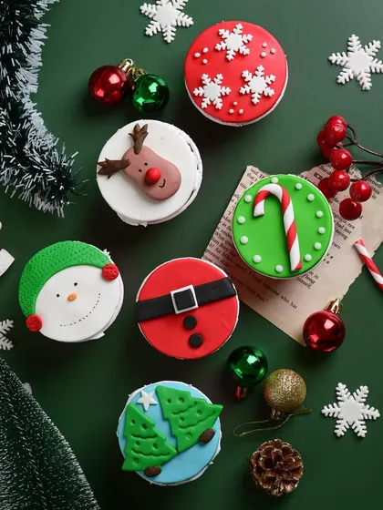 I love getting creative for the holidays. These are some of our hand-decorated Christmas cupcakes, featuring fun designs like Santa's belt, reindeer, and snowmen, all completely eggless and made from scratch.