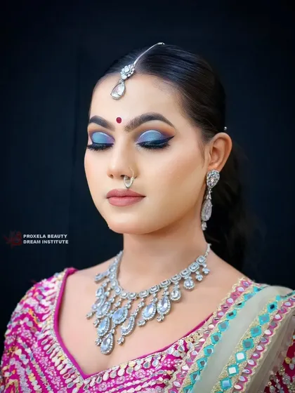 A close-up on the dramatic eye makeup. The blend of deep blues and a sharp wing creates a mysterious and captivating look, perfect for an evening event.