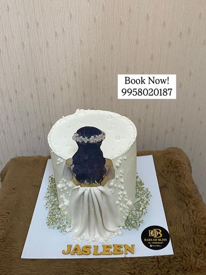 A custom cake I made for a client's birthday, featuring a beautiful illustration of a girl in a white dress. The cake was part of a complete decor package I provided.