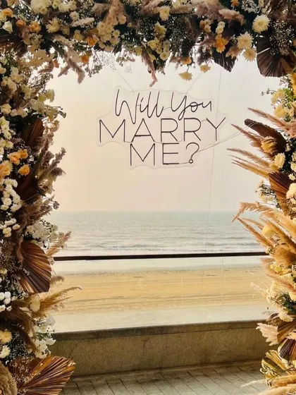 This close-up shot frames the neon sign through the intricate dried flower and pampas grass arrangement. I focus on creating layers and texture in my decor for a rich, high-quality look.