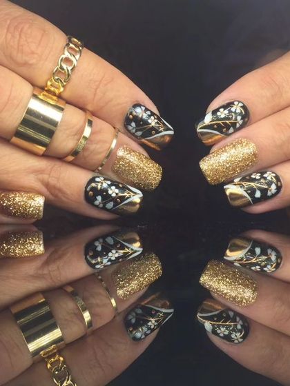 A full view of the luxurious black and gold floral and glitter nail art.