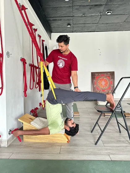 This is a therapeutic inversion for decompressing the lower back. Using a specialized bench, ropes, and a chair, the student can achieve spinal traction safely. This practice is beneficial for anyone, from beginners to experienced yogis.