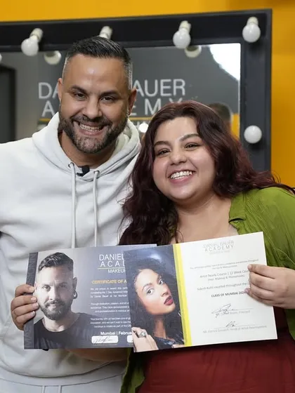 A happy graduate poses with Daniel Bauer. Her journey from student to professional artist starts now.