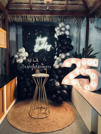 A compact yet stylish setup perfect for smaller spaces or cabanas. The black shimmer wall, neon sign, and marquee numbers create a full party vibe.