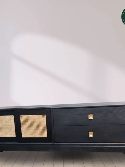 This modern console table features a black finish with woven cane sliding doors and simple brass knobs. It's a beautiful blend of modern design and natural textures.