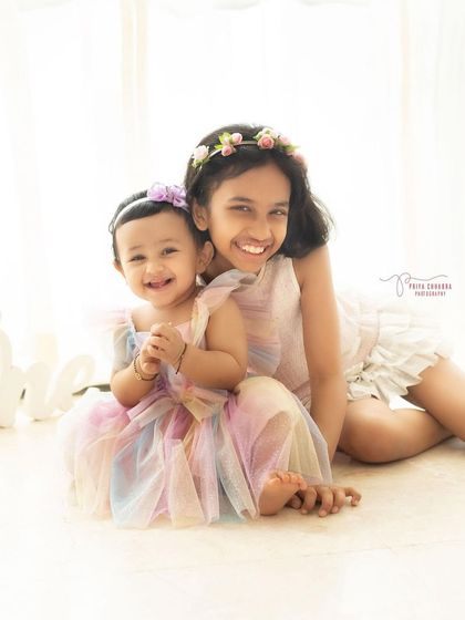 Double the giggles, double the grins! Capturing the sweet and joyful bond between these two adorable sisters in their beautiful pastel dresses.