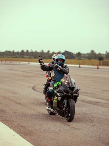 A rider gives a peace sign, enjoying the incredible atmosphere of the Vroom DragMeet.