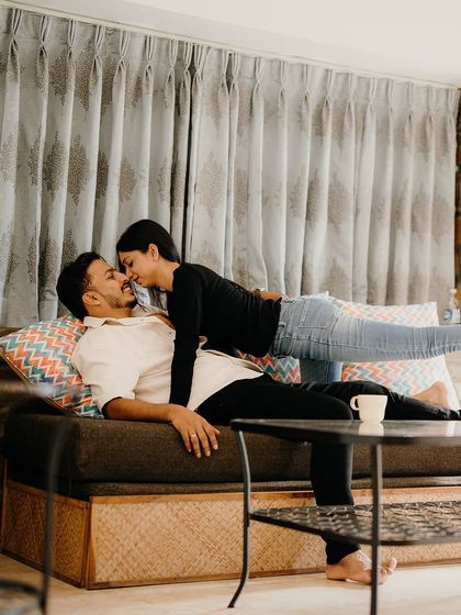 A playful and loving moment on the couch. This candid shot captures the pure fun and affection that is central to their relationship.