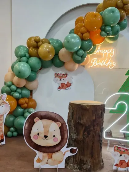 A different angle of our modern jungle theme, highlighting the balloon arch and the cute lion and fox characters.