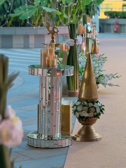 A chic and aesthetic celebration on a city sky deck. The aisle is lined with modern mirrored pedestals, golden decor, and elegant white floral arrangements. 🤍