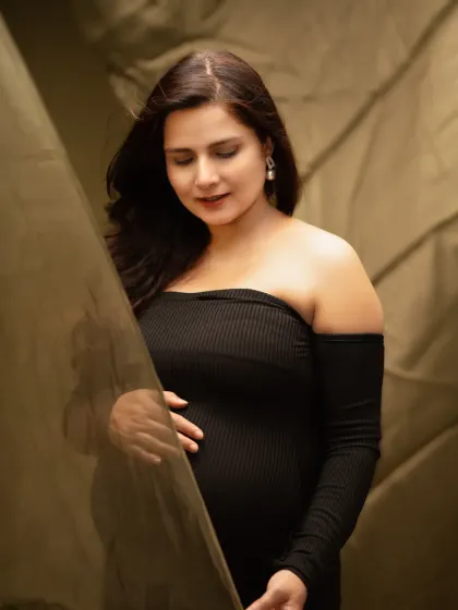 A soft and dreamy solo portrait. The gentle lighting and flowing fabric create an ethereal feel in this beautiful close-up of a mother-to-be.