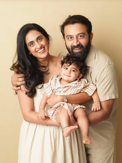 A classic family portrait where everyone is happy and connected. The coordinated neutral outfits give the photo a cohesive and polished look.