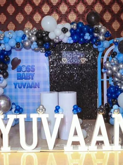 A "Boss Baby" themed first birthday for Yuvaan. The stage features a blue, black, and silver color scheme, a sequin wall, and our popular marquee letters.