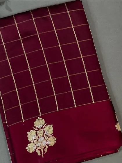 A closer look at the maroon checks pattern Banarasi saree with its elegant embroidered buta.