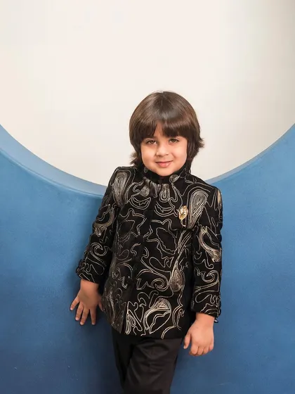 This black velvet bandhgala jacket features a custom gold paisley embroidery. I added a small brooch to the collar for an extra touch of regal flair, perfect for a wedding guest outfit.